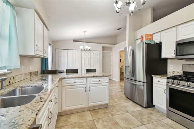 kitchen featuring white cabinets, appliances with stainless steel finishes, and vaulted ceiling