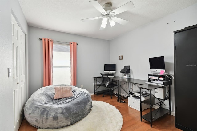 office area featuring wood-type flooring, a textured ceiling, and ceiling fan