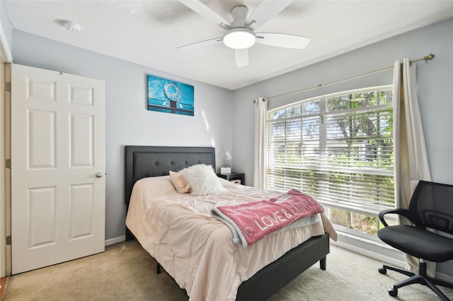 bedroom featuring carpet, ceiling fan, a textured ceiling, and multiple windows