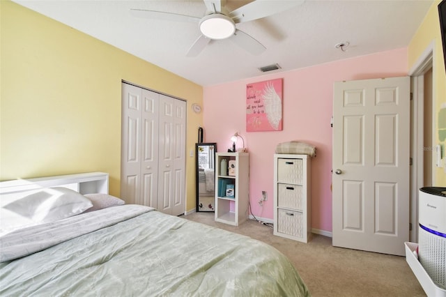 bedroom featuring ceiling fan, light carpet, and a closet