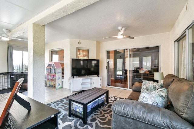 tiled living room with ceiling fan and a textured ceiling