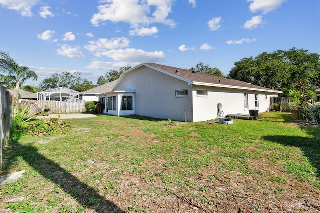 rear view of property with a lawn and a patio area