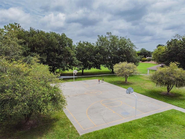 exterior space featuring basketball hoop and a yard