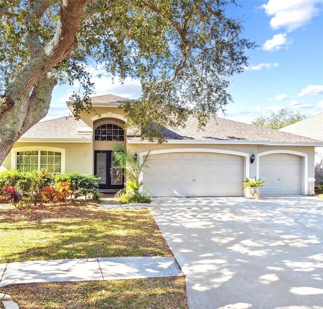 view of front of property with a garage and french doors