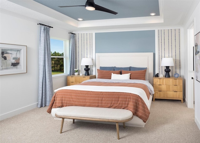 bedroom featuring carpet floors, ceiling fan, and a raised ceiling