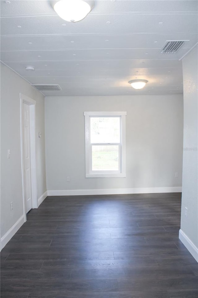 spare room with dark wood-type flooring