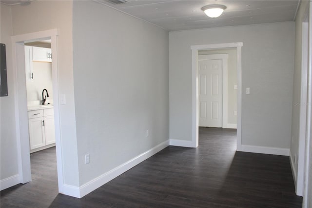 empty room featuring electric panel, sink, and dark hardwood / wood-style floors