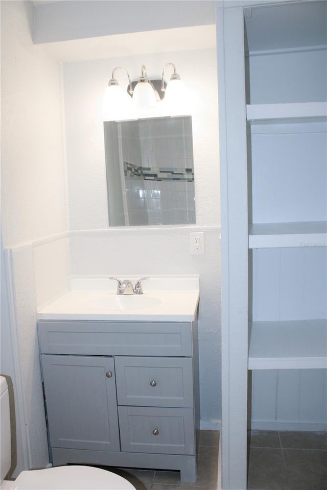 bathroom featuring tile patterned flooring, vanity, and toilet