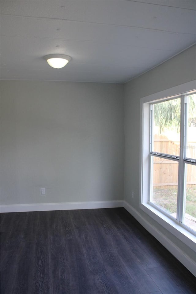 unfurnished room with dark wood-type flooring