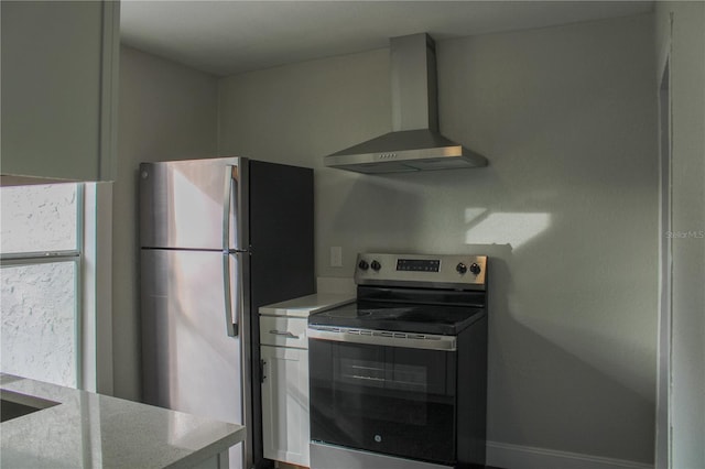 kitchen with stainless steel appliances and wall chimney range hood