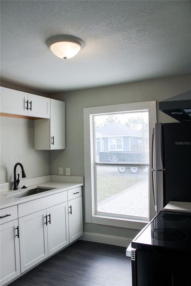 kitchen featuring white cabinets, stainless steel refrigerator, dark hardwood / wood-style floors, and a textured ceiling