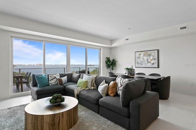 tiled living room with a wealth of natural light and a water view