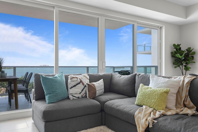 tiled living room featuring a water view