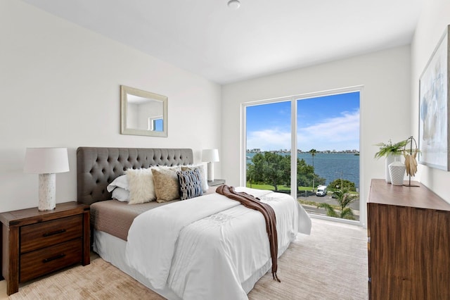 carpeted bedroom with a water view and multiple windows