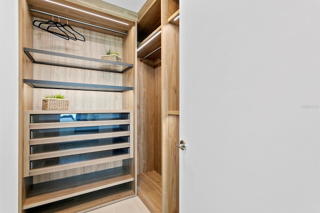 walk in closet with light hardwood / wood-style floors