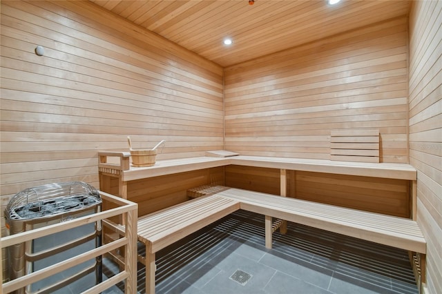 view of sauna featuring wood walls, tile patterned flooring, and wooden ceiling