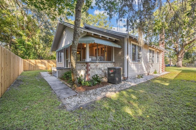 exterior space featuring central AC unit and a lawn