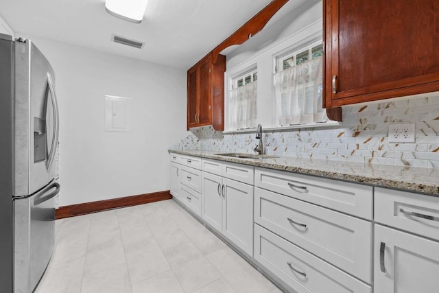 kitchen featuring backsplash, stainless steel fridge with ice dispenser, light stone countertops, sink, and white cabinets