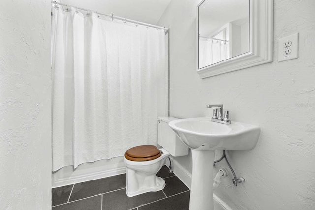 bathroom featuring toilet, shower / bath combo, and tile patterned floors