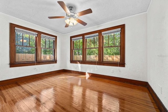 spare room featuring crown molding, plenty of natural light, hardwood / wood-style flooring, and ceiling fan