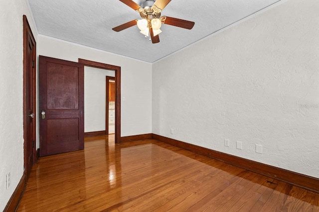 spare room with ornamental molding, hardwood / wood-style floors, ceiling fan, and a textured ceiling