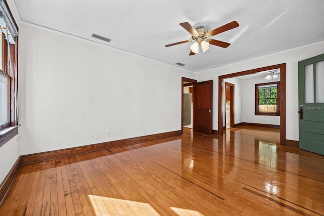 unfurnished room featuring crown molding, hardwood / wood-style flooring, and ceiling fan