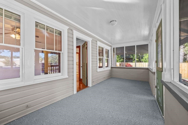 unfurnished sunroom with ceiling fan and plenty of natural light