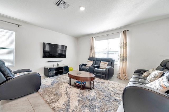 tiled living room featuring a textured ceiling