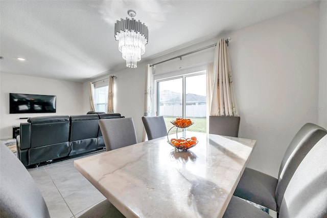 tiled dining room featuring an inviting chandelier