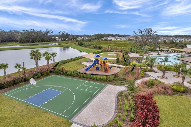 view of basketball court with a playground and a water view