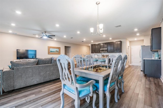 dining room featuring ceiling fan with notable chandelier and light wood-type flooring