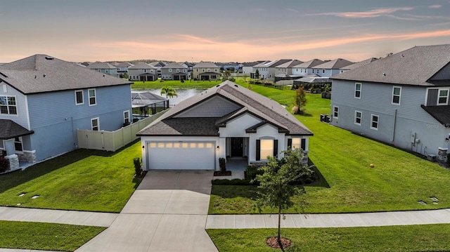 view of front of house with a water view, a garage, and a lawn