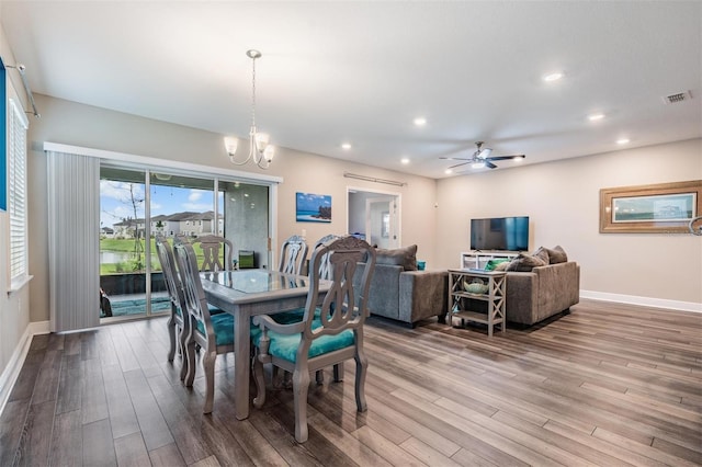 dining room with hardwood / wood-style floors and ceiling fan with notable chandelier