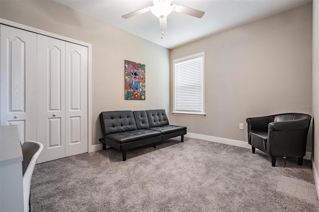 sitting room with ceiling fan and carpet