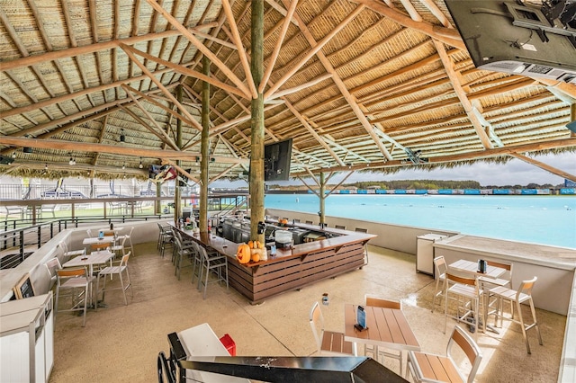 exterior space featuring a gazebo, a water view, a view of the beach, and a bar