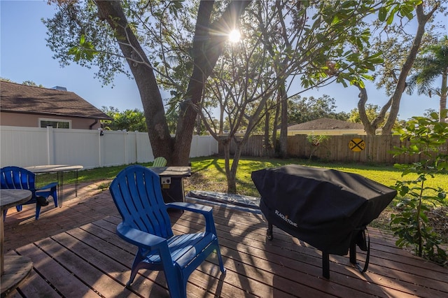 deck with a grill and a yard