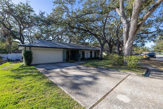 single story home featuring a garage and a front yard