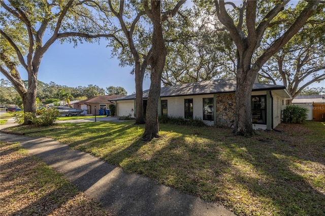 ranch-style house featuring a garage and a front lawn