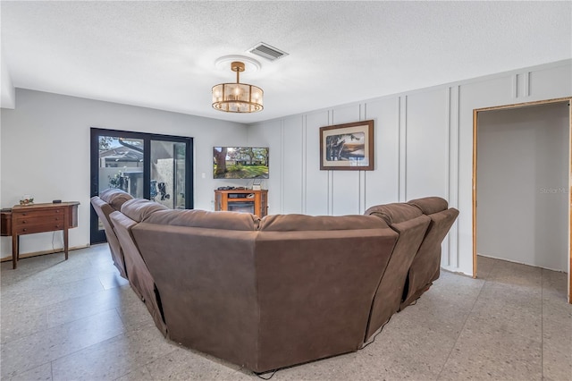 living room featuring a textured ceiling and a notable chandelier