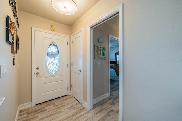 entryway with light hardwood / wood-style floors and a textured ceiling