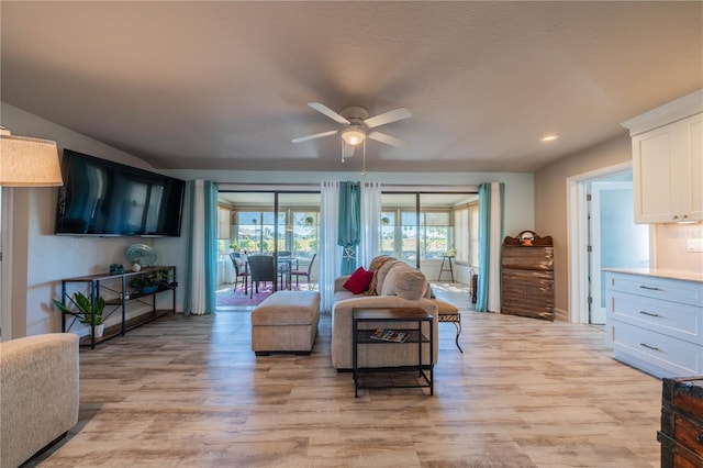 living room with ceiling fan and light hardwood / wood-style flooring