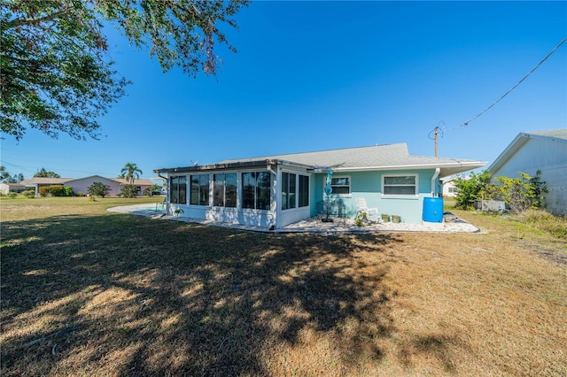 rear view of property featuring a sunroom and a yard