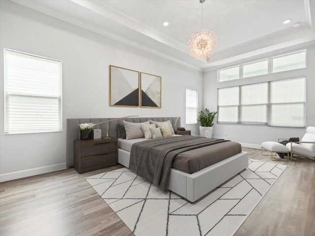 bedroom with a raised ceiling, light hardwood / wood-style flooring, and ornamental molding