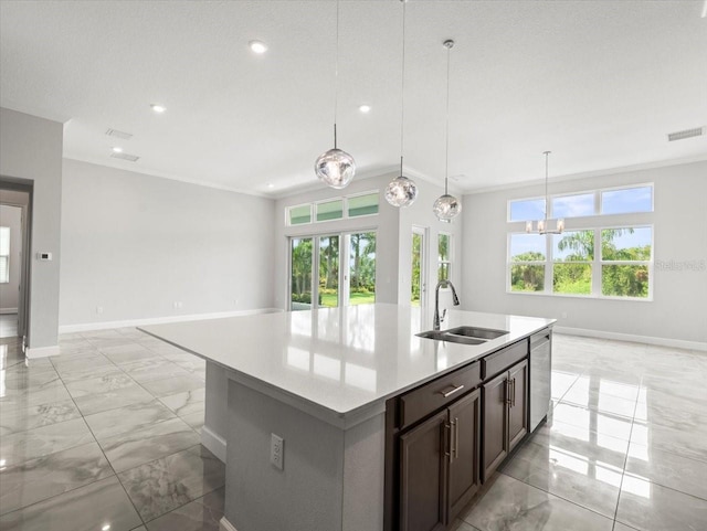 kitchen with a center island with sink, sink, decorative light fixtures, and plenty of natural light