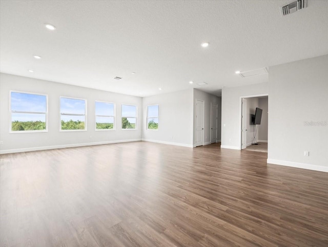 unfurnished living room featuring a textured ceiling and dark hardwood / wood-style flooring