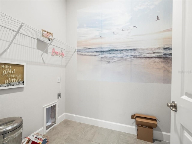 laundry room with electric dryer hookup and light tile patterned flooring