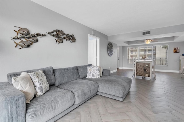 living room featuring ceiling fan and parquet flooring