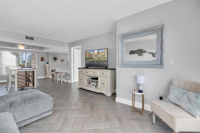 living room featuring ceiling fan and parquet flooring