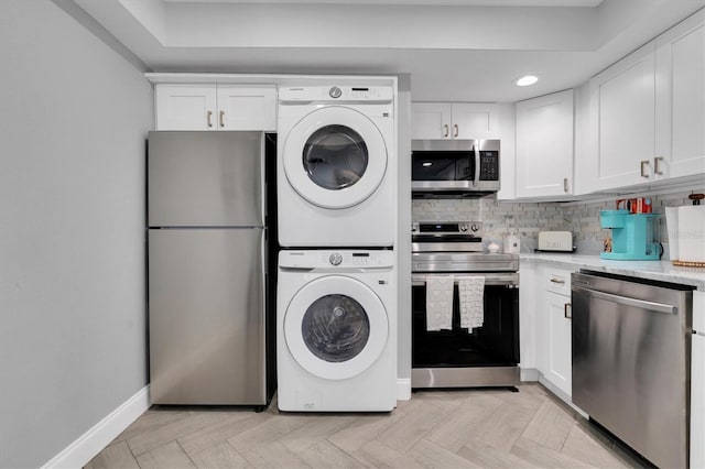 9000 Commodore Dr Unit 401, Seminole, FL 33776 - laundry area with stacked washer and clothes dryer, baseboards, and recessed lighting