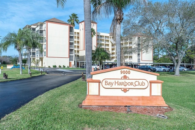 9000 Commodore Dr Unit 401, Seminole, FL 33776 - community sign featuring a lawn and uncovered parking
